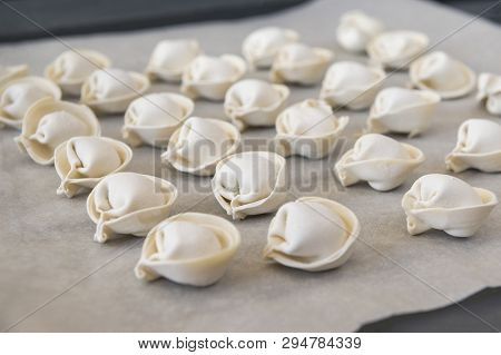 Dumplings, Many  Raw Meat Ravioli Are On The Baking Sheet In Rows , Semifinished Products