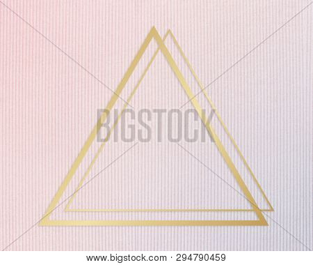 Gold ftriangle rame on a pinkish blue fabric background