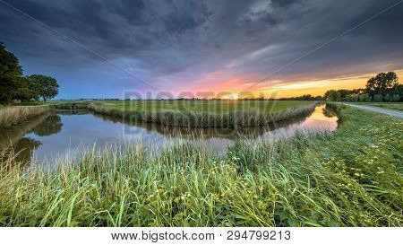 Wide Angle View Of Landscape Over River Bend At Sunset In Flat Agricultural Landscape In Groningen P
