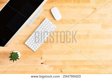 Desktop Computer. Top View Of Wooden Office Desk With Large Desktop Computer, Keyboard, Mouse And Pl