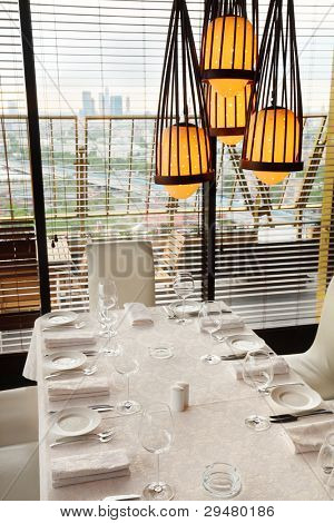 belle au service de la table avec une nappe blanche dans le restaurant ; lampe jaune ci-dessus