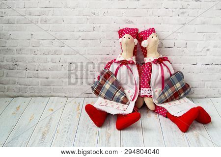Tilda Doll, Soft Toy With A Heart, Sitting On A Wooden Background. Handcraft Concept. There Is A Pla