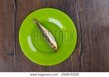 Cold Smoked Baltic Herring On An Green Plate Over A Wooden Background. Smoked Baltic Herring Smoked 