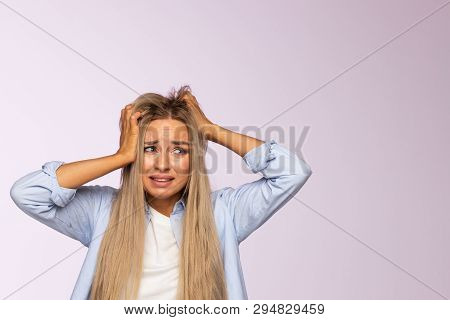 Closeup Studio Portrait Of Anxious Pretty Young European Female Clutching At Her Head, Awkward Feeli