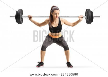 Full length shot of a young female athlete lifting weigths isolated on white background
