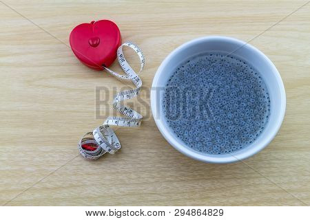 Sweet Basil In White Cup And Red Measuring Tape  Shape Heart On Wooden Background.indicate For Slim 