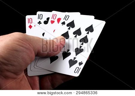 Four Of A Kind In Left Hand, Gambling, Poker, Casino Games On A Black Background.