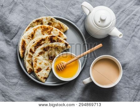 Indian Paratha Flatbread With Honey And Masala Tea On Grey Background, Top View