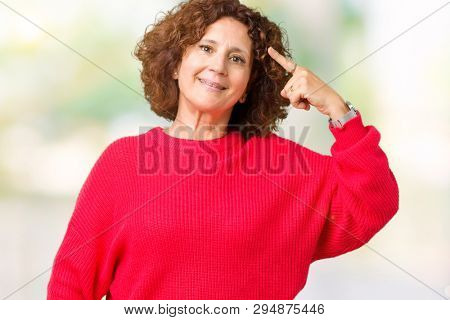 Beautiful middle ager senior woman red winter sweater over isolated background Smiling pointing to head with one finger, great idea or thought, good memory