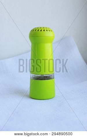 Limegreen Peppermill. Kitchen Equipment For Grinding Spices On A Linen Background. Front View.