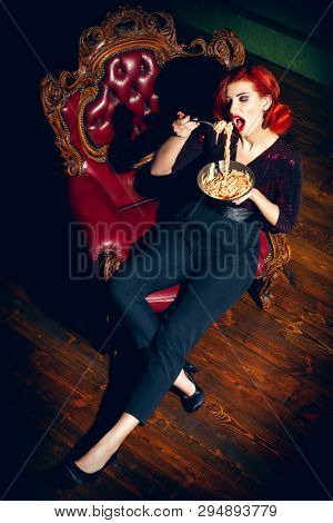 A full length portrait of a beautiful woman posing in the vintage interior and having a meal. Beauty, fashion, interior.