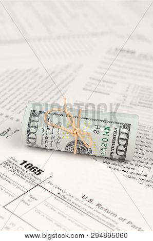 1065 U.s. Return Of Parentship Income Form With Roll Of American Dollar Banknotes