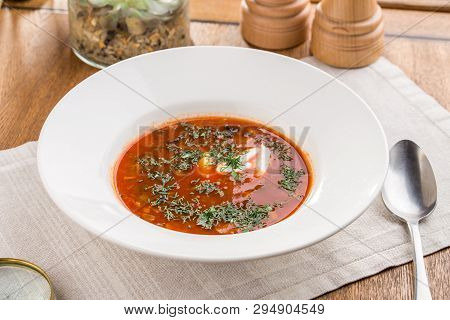 Red Beetroot Soup Borshch With Beef And Sour Cream On Wooden Table Side View