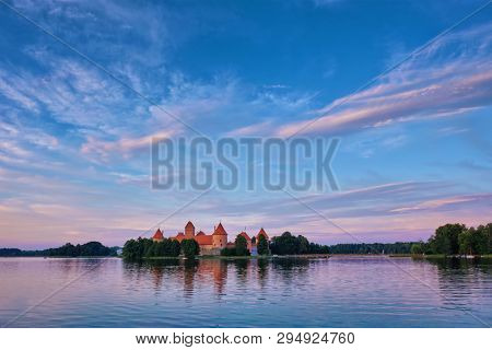 Trakai Island Castle in lake Galve, Lithuania on sunset with dramatic sky reflecting in water. Trakai Castle is one of major tourist attractions of Lituania