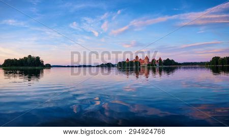 Panorama of Trakai Island Castle in lake Galve, Lithuania on sunset with dramatic sky reflecting in water. Trakai Castle is one of major tourist attractions of Lituania