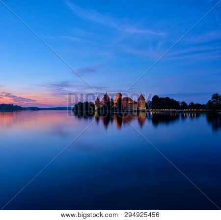 Evening view of Trakai Island Castle in lake Galve illuminated in the night, Lithuania. Square format image