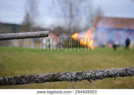 Close Up Of Fence With A Fire Blurred In The Background. Selective Focus. Walpurgis Night Celebratio