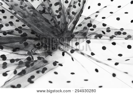 Abstract Composition Of Black Tulle Material On White Background. Selective Focus. Sewing Concept
