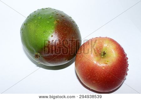 Green Mango And Red Apple In Water Drops On White Background