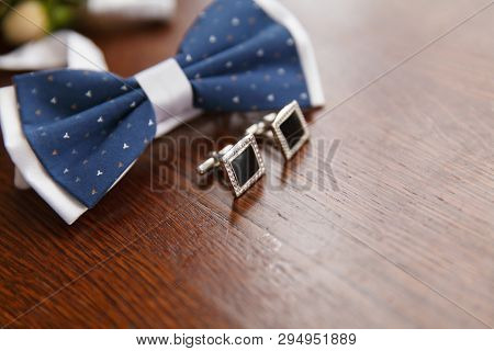 Blue With White Bow Tie For The Groom And Cufflinks Lie On A Wooden Table