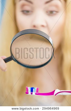 Beautiful Perfectionist Young Woman Checking Her Tooth Brush Through Manifying Loupe Glass. Hygiene,
