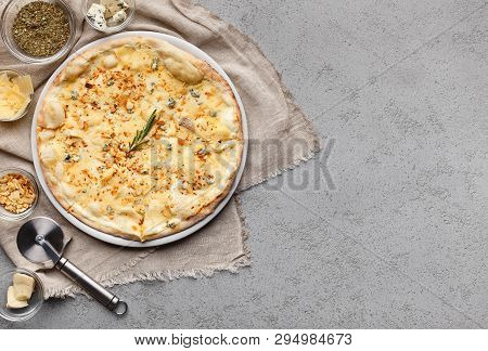 Four Cheese Pizza Decorated With Chopped Nuts On Grey Table With Copy Space, Top View