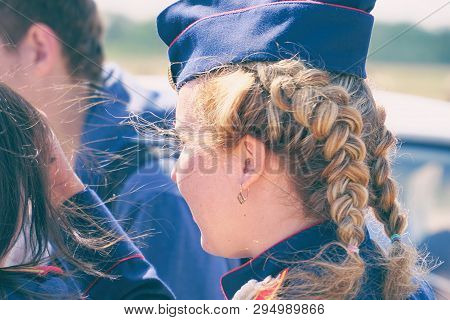 Woman With Pigtails In Uniform In A Forage-cap. Rear View