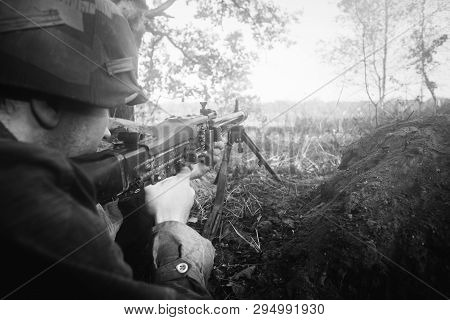 Hidden Re-enactor Dressed As German Wehrmacht Infantry Soldier In World War Ii Aiming A Machine Gun 