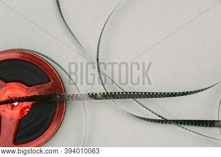 Red Old Film Reel On A Green Background. 16mm Film Reel. Filmstrip Top View. Flat Lay.