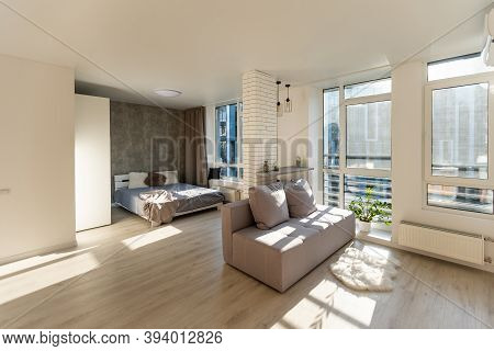 Open Living Room With Couch, Brick Wall And Small Kitchen