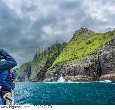 Unrecognizable Tourists Over Boat Astonished Under The Impressive Vestmanna Cliffs