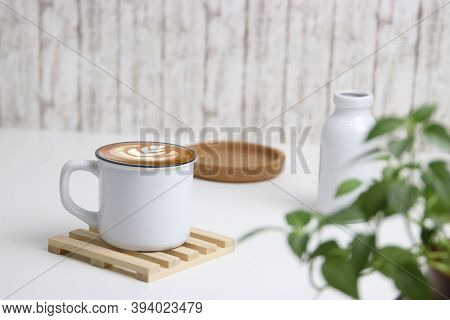 Latte Art Coffee In White Mug With White Background And Green Leaves