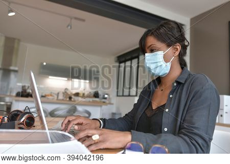 Office worker wearing surgical face mask in open space area