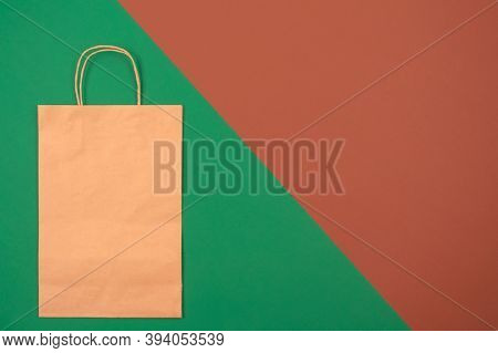 Mockup Image Of Brown Kraft Paper Bag - On Green And Brown Background With Copyspace. Recycled Kraft