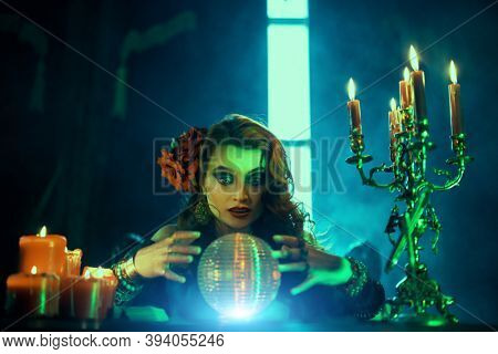 Bewitching fortune teller woman reading future on magical crystal ball.