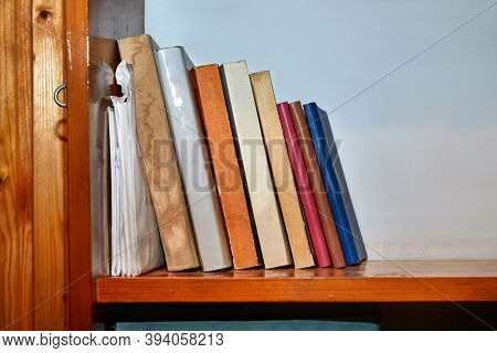 Bookshelf with series of books in piles and rows
