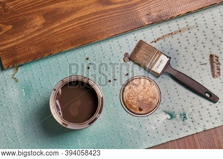 Painting lumber with wood stain coloring with paint brush