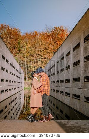 Couple Men And Woman Hiking In The Forest During Autumn And Small Streaming Water River With Fall Co