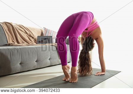 Vitality. Beautiful Young Woman Working Out Indoors, Doing Yoga Exercise On Gray Mat At Home. Long H