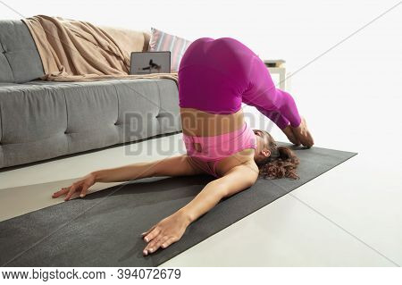 Vitality. Beautiful Young Woman Working Out Indoors, Doing Yoga Exercise On Gray Mat At Home. Long H
