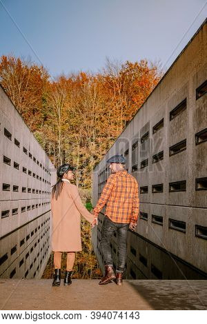 Couple Men And Woman Hiking In The Forest During Autumn And Small Streaming Water River With Fall Co