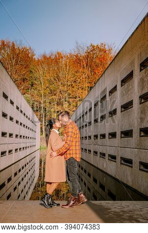 Couple Men And Woman Hiking In The Forest During Autumn And Small Streaming Water River With Fall Co