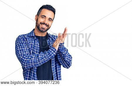 Young hispanic man wearing casual clothes clapping and applauding happy and joyful, smiling proud hands together 
