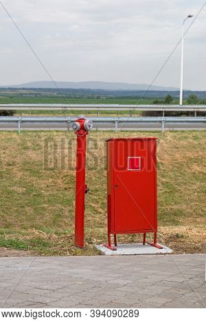 Water Hydrant Pipe And Red Box With Fire Fighters Tools