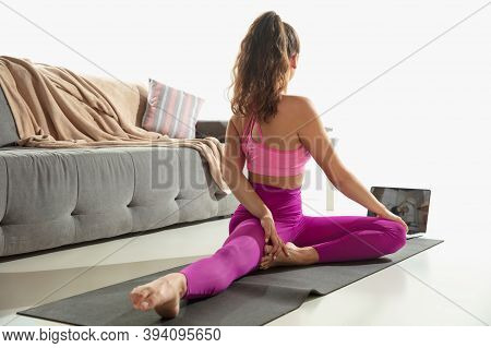 Inspired. Beautiful Young Woman Working Out Indoors, Doing Yoga Exercise On Gray Mat At Home. Long H