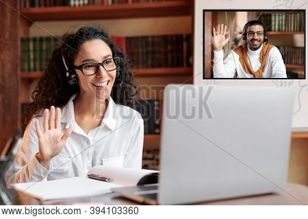 Online Tutoring. Portrait Of Woman In Glasses And Headset Having Video Conference, Sitting At Desk A