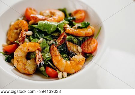 Fresh Salad Plate With Shrimp, Tomato And Mixed Greens On Wooden Background Close Up. Healthy Food.h
