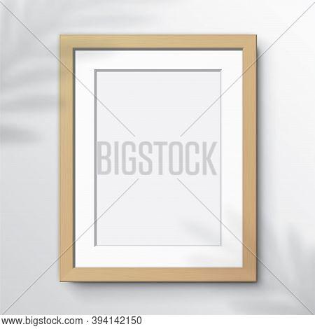 Vertical Wooden Frame, Hanging On A White Wall With Leaf Shadows. Blank Elegant Frame Template, With