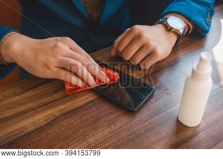 Businessman's Hands Wipe The Phone With A Napkin After Using An Antiseptic