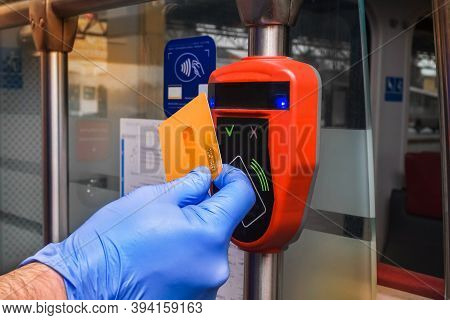 A Man's Hand In A Protective Medical Glove Applies A Card To An Automatic Toll Terminal In A Modern 